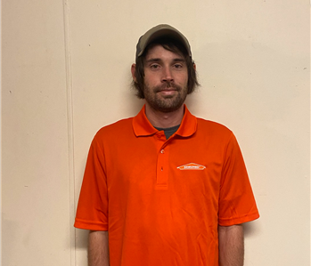 Male Employee of SERVPRO wearing a baseball cap and bright orange short sleeve collared shirt