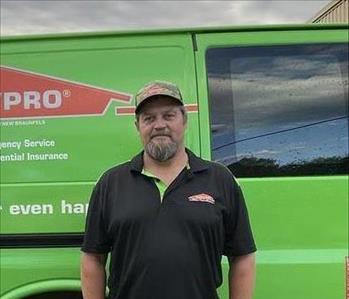 Male Employee of SERVPRO wearing a baseball cap and black short sleeve collared shirt