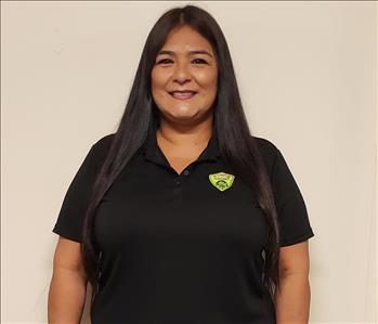 Female Employee wearing a black short sleeve shirt with a company logo on the top right-hand side